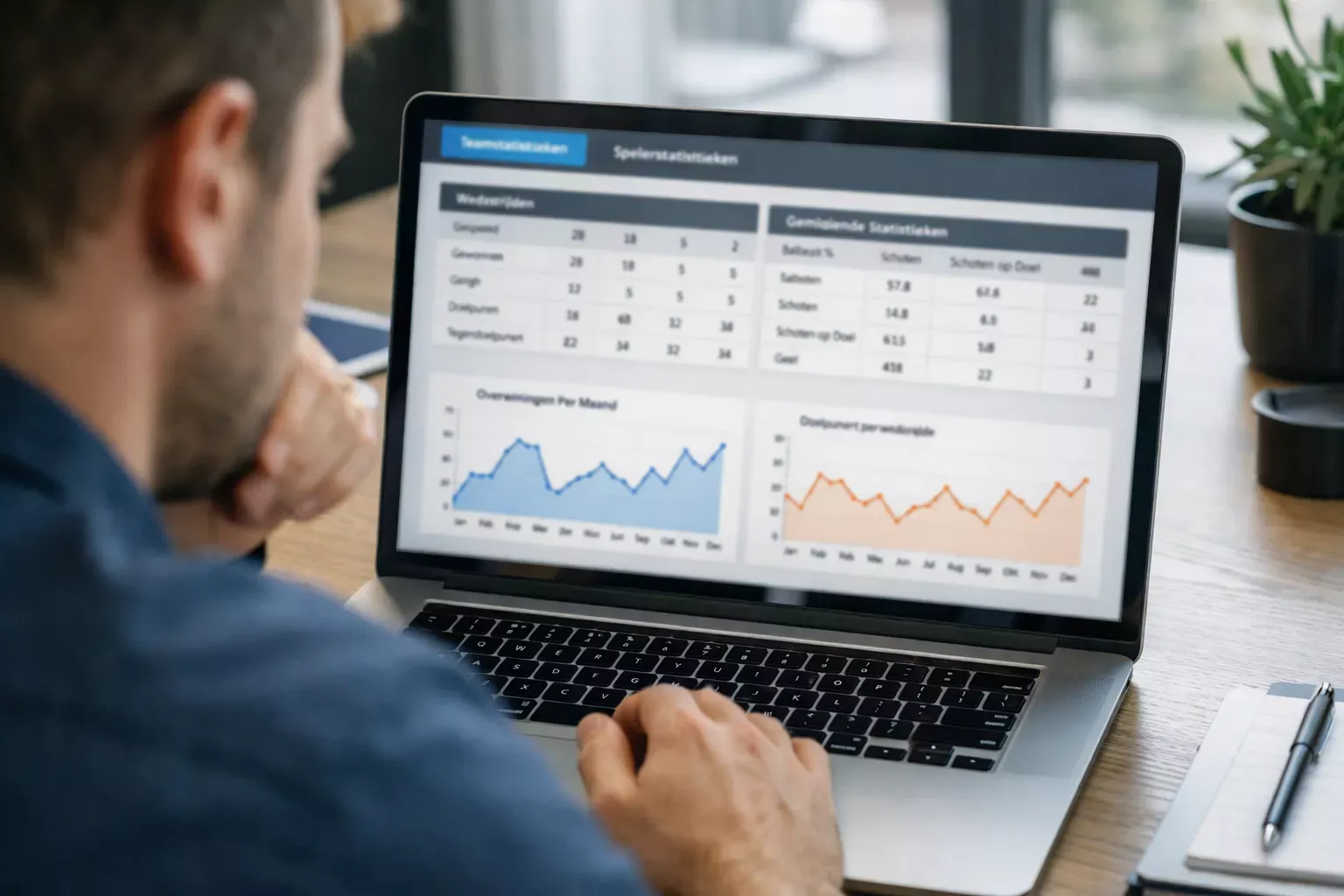 Persoon analyseert sportstatistieken op een laptopscherm